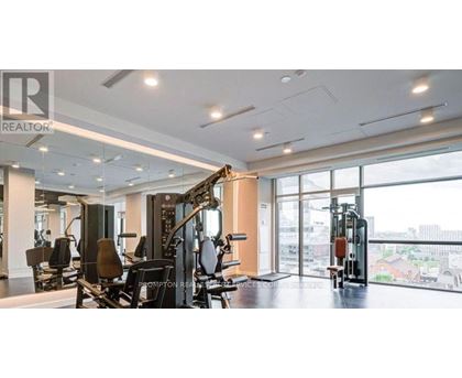 A gym with a row of treadmills and a row of stationary bikes.