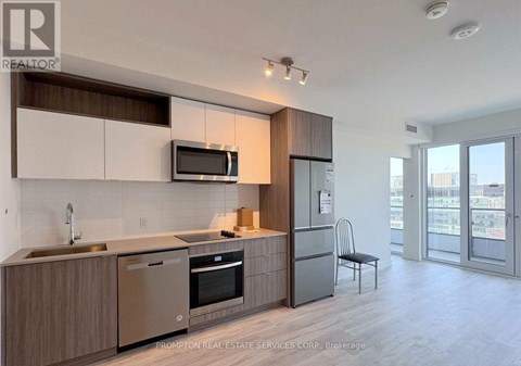 A modern kitchen with a stainless steel dishwasher and refrigerator.