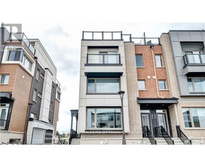 A modern apartment building with balconies and black railings.