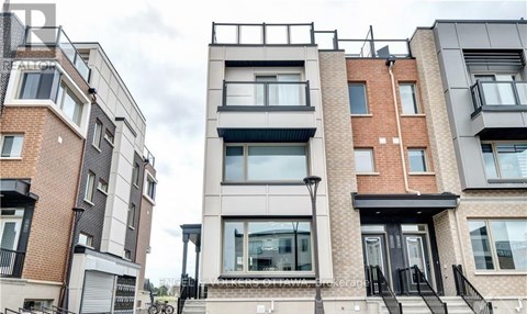 A modern apartment building with balconies and black railings.