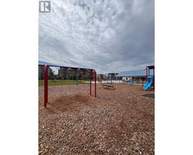 A playground with a red swing set and a blue slide.