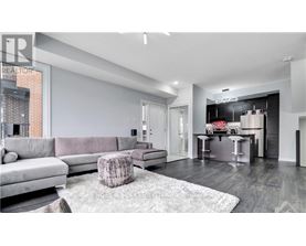 A modern living room with a grey sofa and a grey rug.