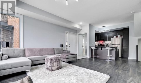 A modern living room with a grey sofa and a grey rug.