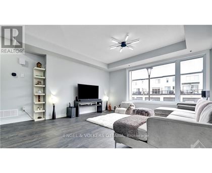 A modern living room with a grey sofa and a television.