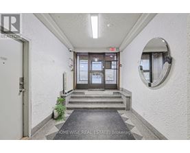 A hallway with a door and a mirror on the wall.
