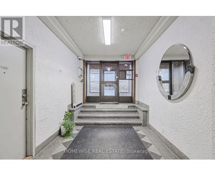 A hallway with a door and a mirror on the wall.