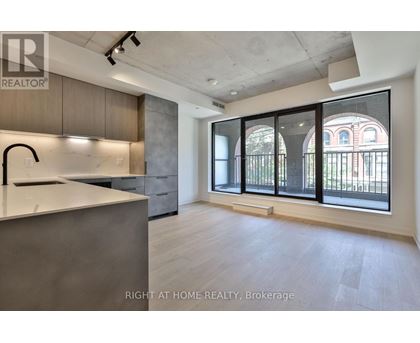 A modern kitchen with a large island and a view of a building outside the window.