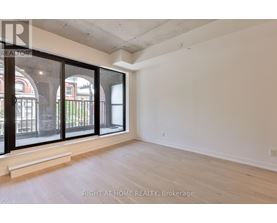 A room with a large window and wooden flooring.