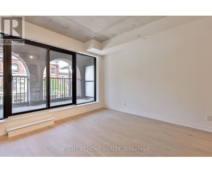 A room with a large window and wooden flooring.