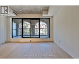 A room with a large window and wooden flooring.