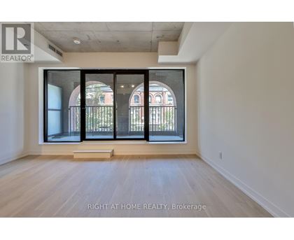 A room with a large window and wooden flooring.
