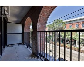 A balcony with a black railing and a brick wall.