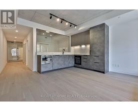 A spacious kitchen with wooden floors and modern appliances.