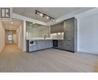A spacious kitchen with wooden floors and modern appliances.