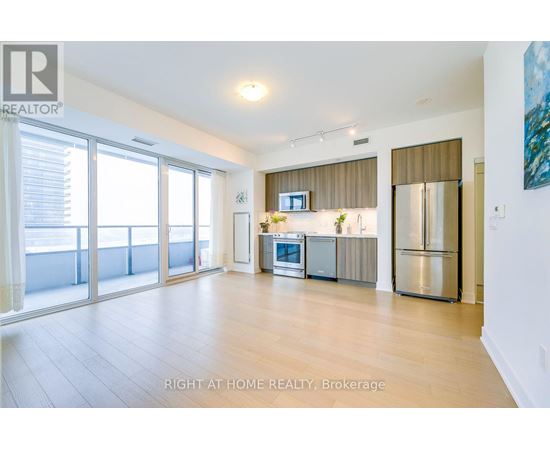 A spacious kitchen with a refrigerator, microwave, and oven.