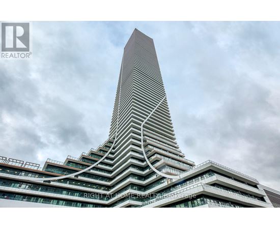 A tall building with a unique curved design stands against a cloudy sky.