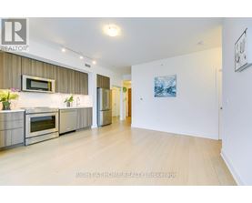 A modern kitchen with stainless steel appliances and wooden flooring.