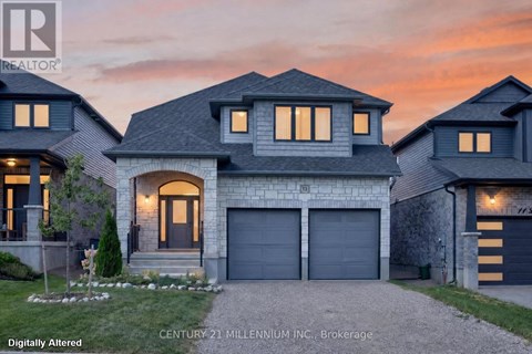 A house with a garage and a driveway in front of it.