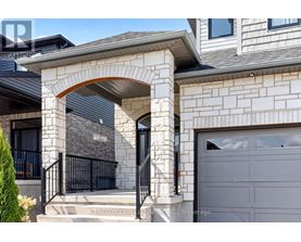 A house with a grey garage door and a stone archway entrance.