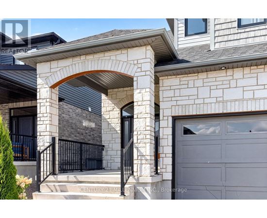 A house with a grey garage door and a stone archway entrance.