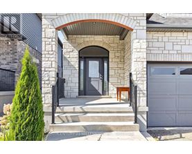 A house with a stone facade and a black gate.