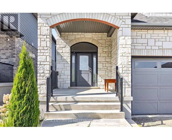 A house with a stone facade and a black gate.