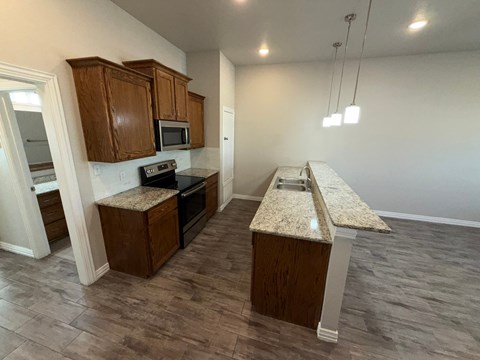 A kitchen with wooden cabinets and granite countertops.