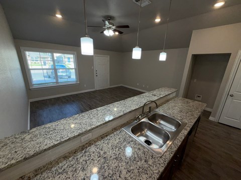 A kitchen with granite countertops and a ceiling fan.