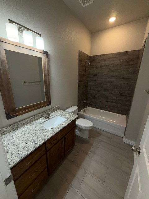 A bathroom with a sink, toilet, and bathtub.
