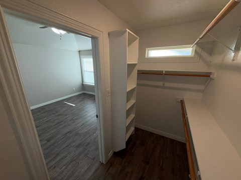 A room with a window and a wooden floor.
