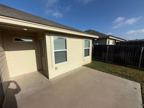 A house with a garage and a fence in the background.