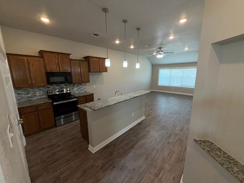 A kitchen with wooden cabinets and a granite countertop.