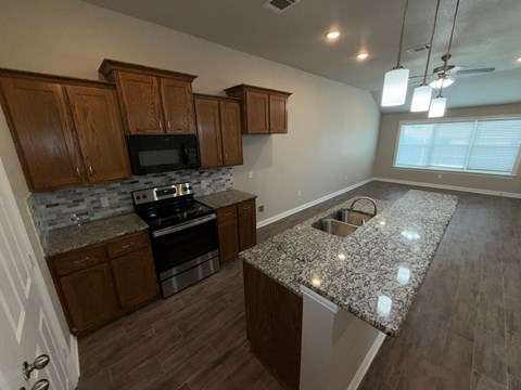 A kitchen with wooden cabinets and granite countertops.