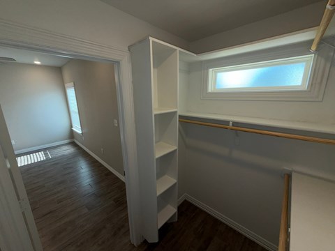 A room with a window and a wooden floor.