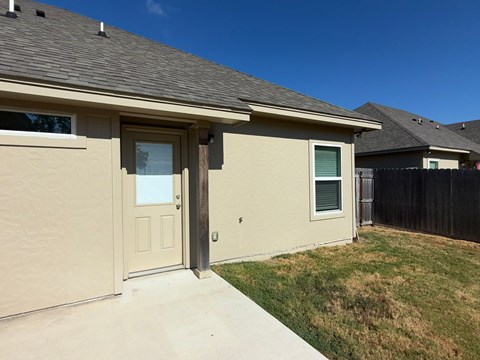 A house with a brown roof and a tan wall.
