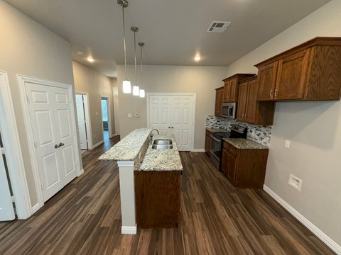 A kitchen with wooden cabinets and a granite countertop.