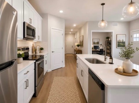 A modern kitchen with white cabinets and stainless steel appliances.