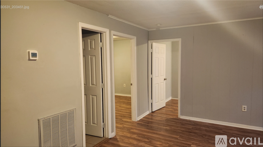 A room with a white door and a window with blinds.