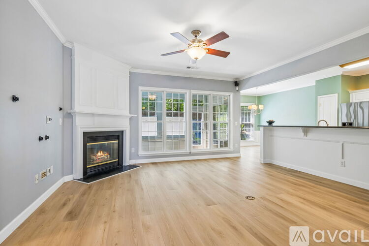 A spacious living room with a fireplace and a ceiling fan.