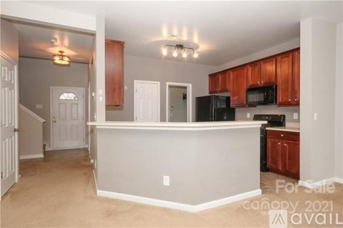 A kitchen with a counter and cabinets is for sale.