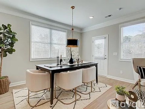 A dining room with a table and chairs.