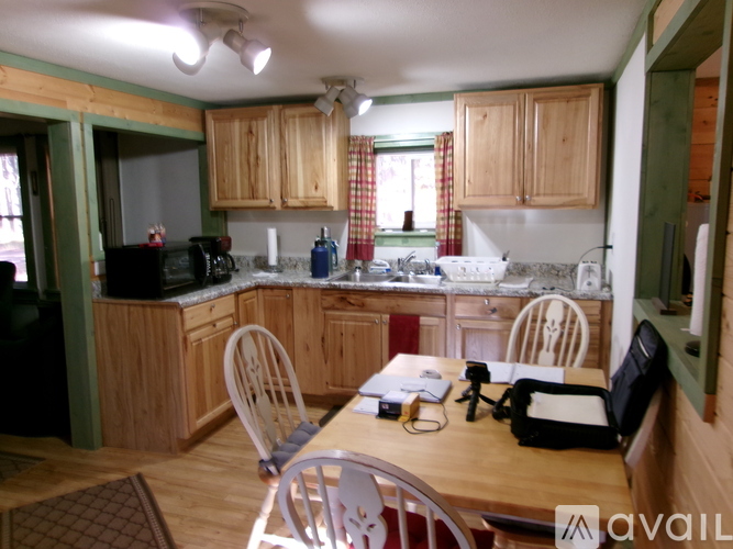 A kitchen with wooden cabinets and a table with chairs.