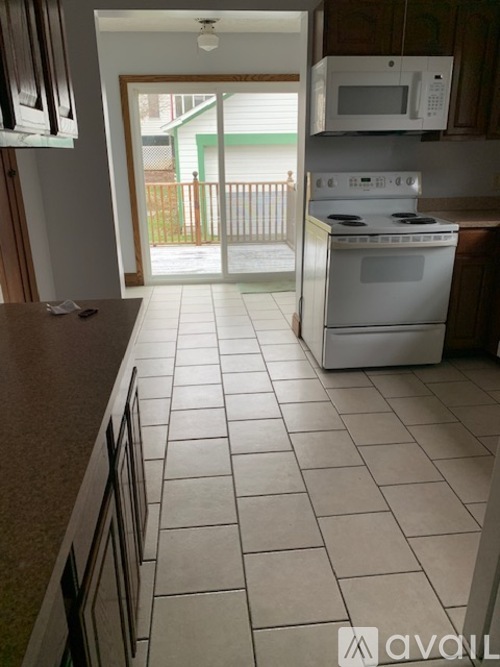A kitchen with white appliances and a white stove.