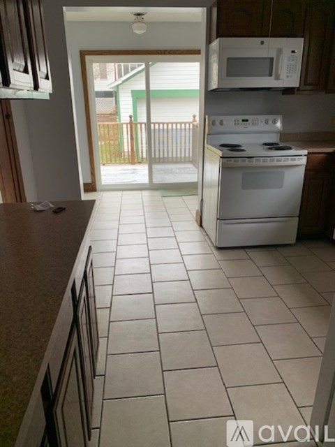 A kitchen with white appliances and a white stove.