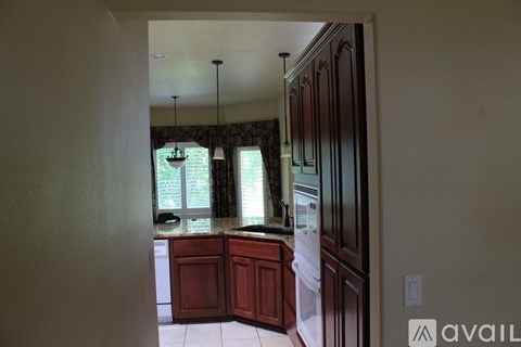 A kitchen with wooden cabinets and a window.