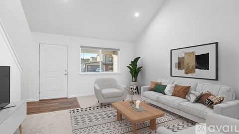 A living room with a white couch, a coffee table, and a painting on the wall.