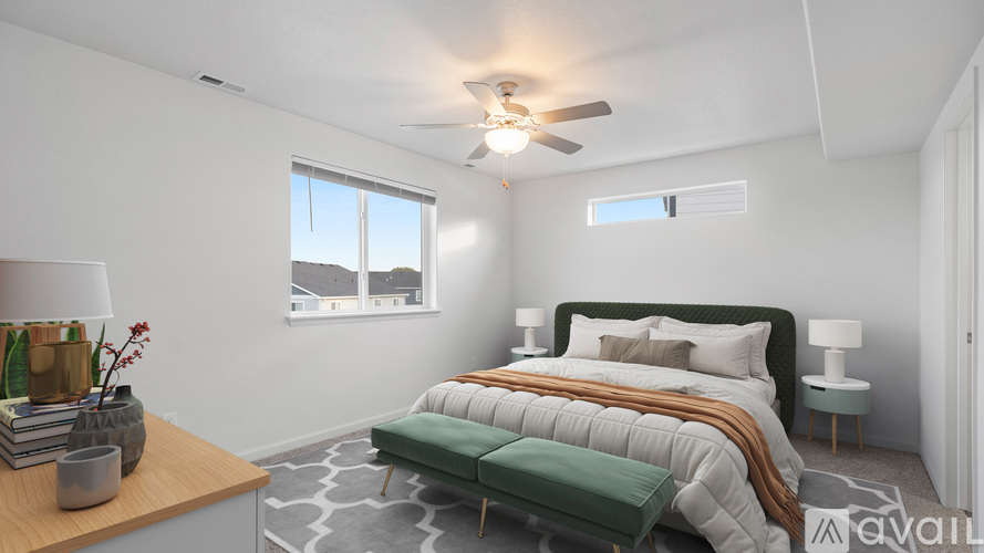 A bedroom with a large bed and a ceiling fan.