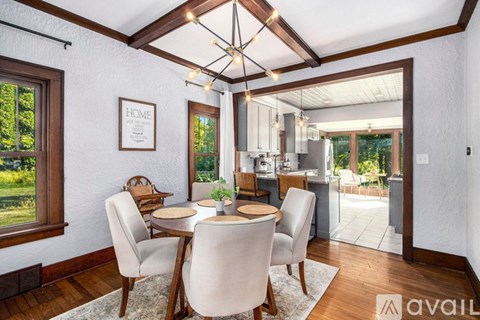 A dining room with a table set for four and a view of the backyard.
