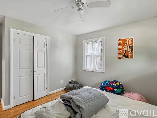 A bedroom with a bed, pillows, and a ceiling fan.