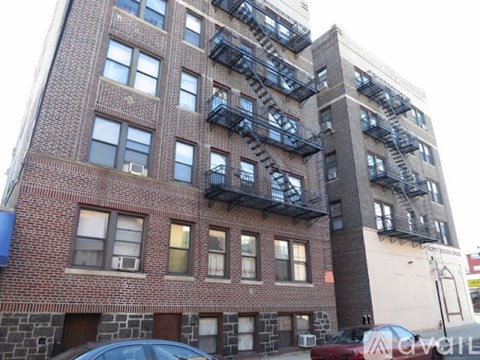 A tall brick building with a fire escape on the side.